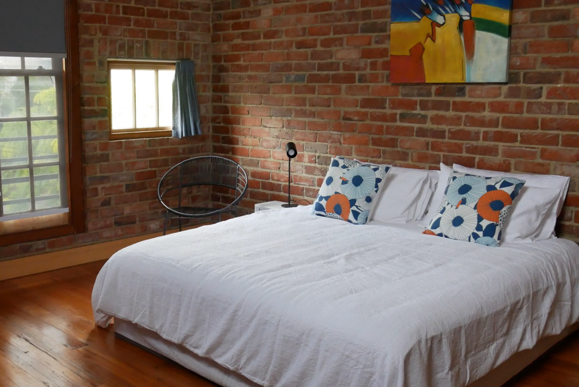 Bedroom with exposed brick and white bed linen