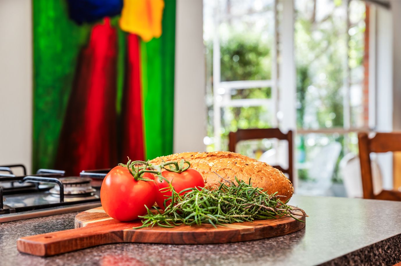 Bread, tomatoes and rosemary on a kitchen bench