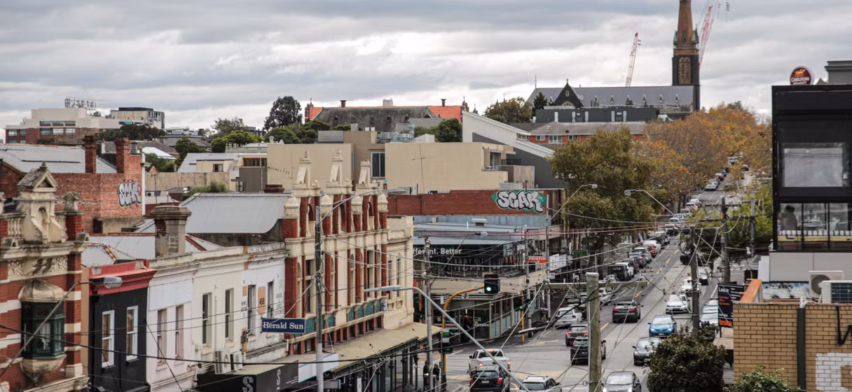 Elevated view of shopfronts, traffic and a church spire in Richmond