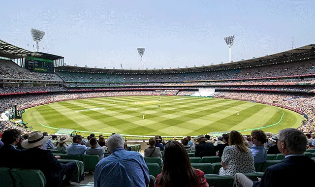 Cricket underway at the MCG with a crowd in the stands